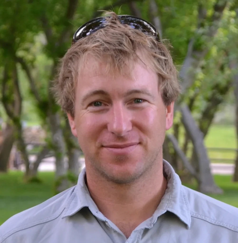 Portrait of drone pilot and cinematographer Colin Witherill outdoors under trees