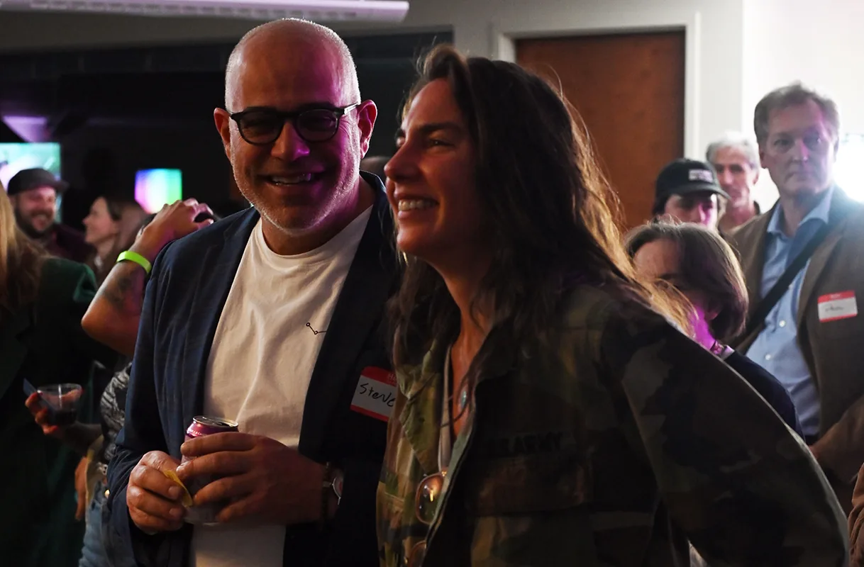 Smiling attendees in a crowded room at a Boulder County Film Commission Schmoozer