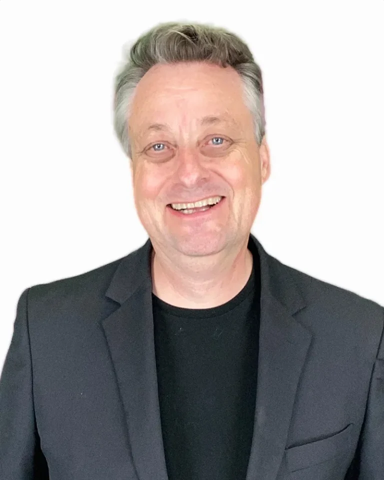 Portrait of filmmaker Tom Parkin in a dark blazer against a white background