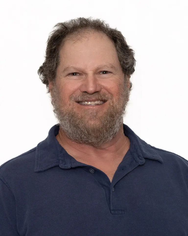 Portrait of Bruce Borowsky, Boulder County Film Commissioner, in a navy polo shirt against a white background