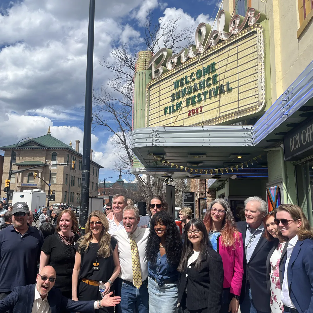 Community members gathered outside the Boulder Theater beneath its marquee reading “Welcome Sundance Film Festival 2027”
