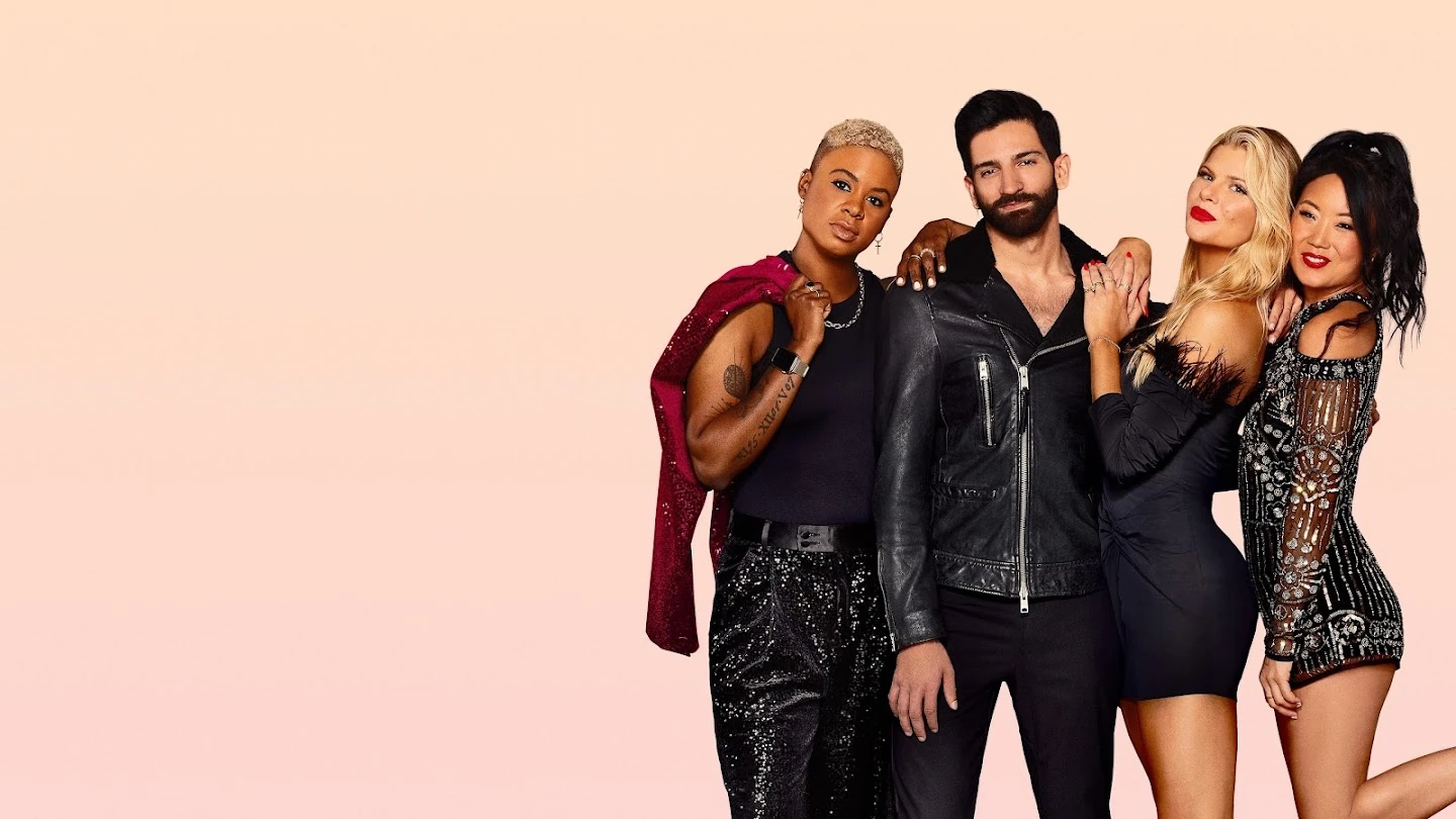 Four cast members in black evening wear stand close together on the right against a soft peach background.