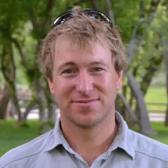 Portrait of drone pilot and cinematographer Colin Witherill outdoors under trees
